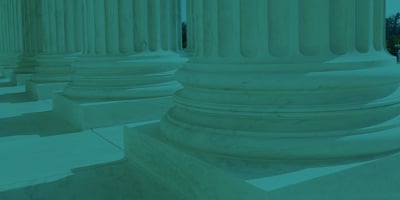 Teal-tinted photograph of the bases of several Doric columns.